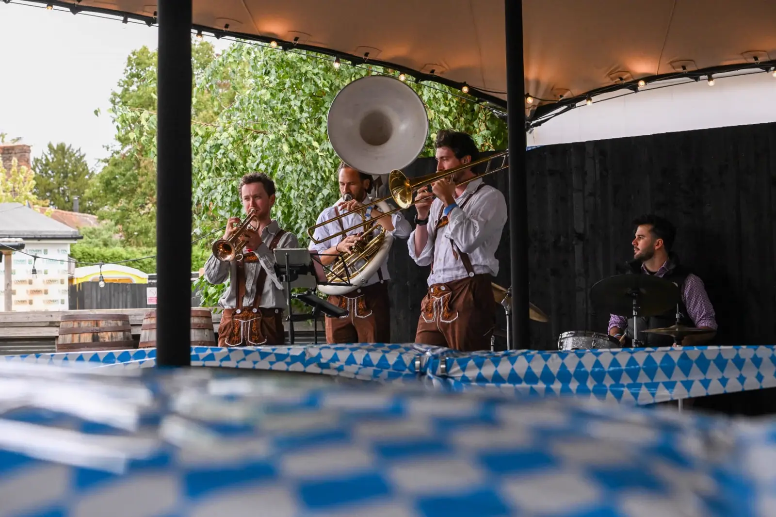 An oompah band in lederhosen playing under a canopy before kick-off