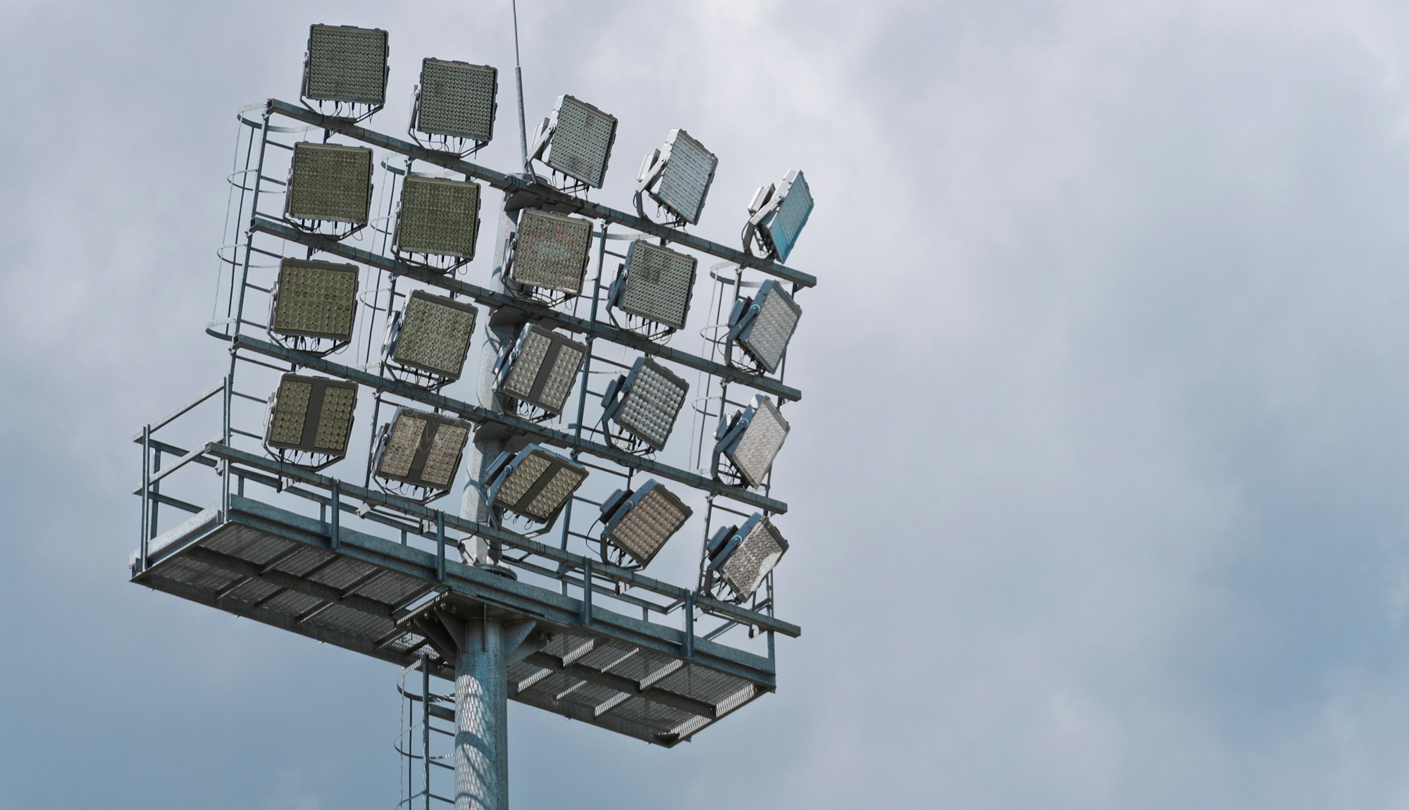 A floodlight tower standing against a heavy sky