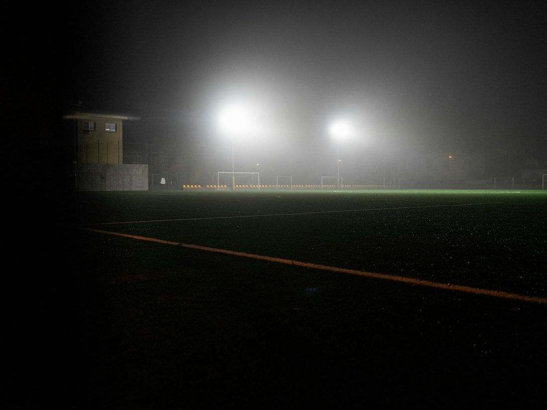 A quiet floodlit pitch in fog