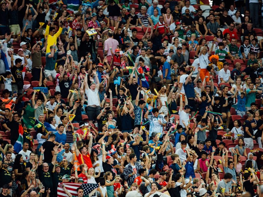 Supporters packed together with arms raised